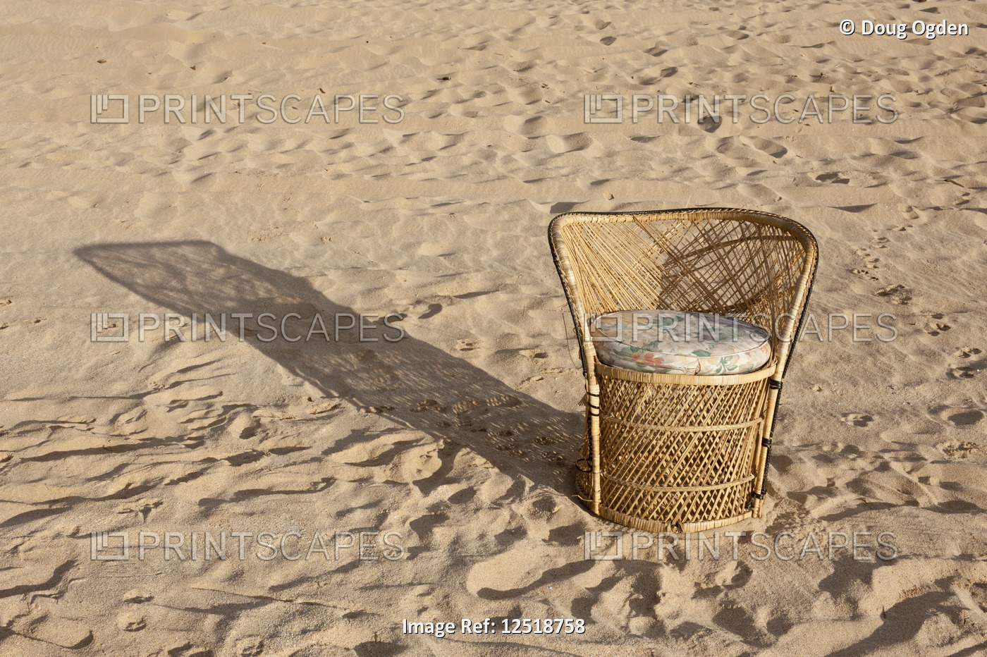 Wicker Chair with shadow on the sandy Polihale, Barking Sands Beach.  Kauai, ...