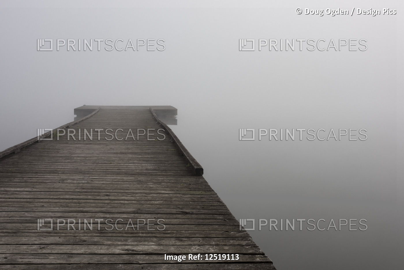 A small wooden dock with dense fog at the end over the water of Scott Lake in ...