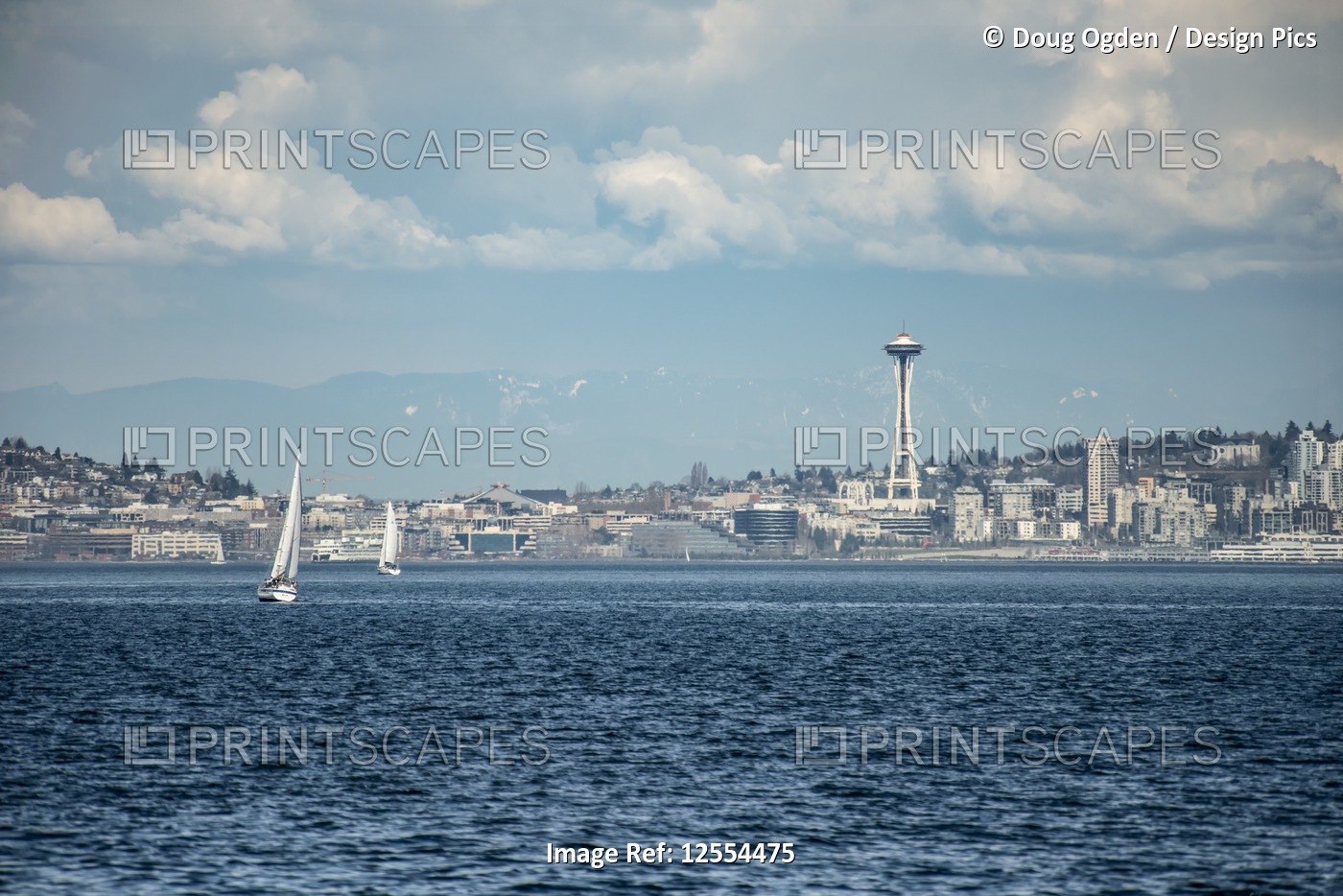 The city of Seattle and the iconic Space Needle as sail boats ply the waters of ...