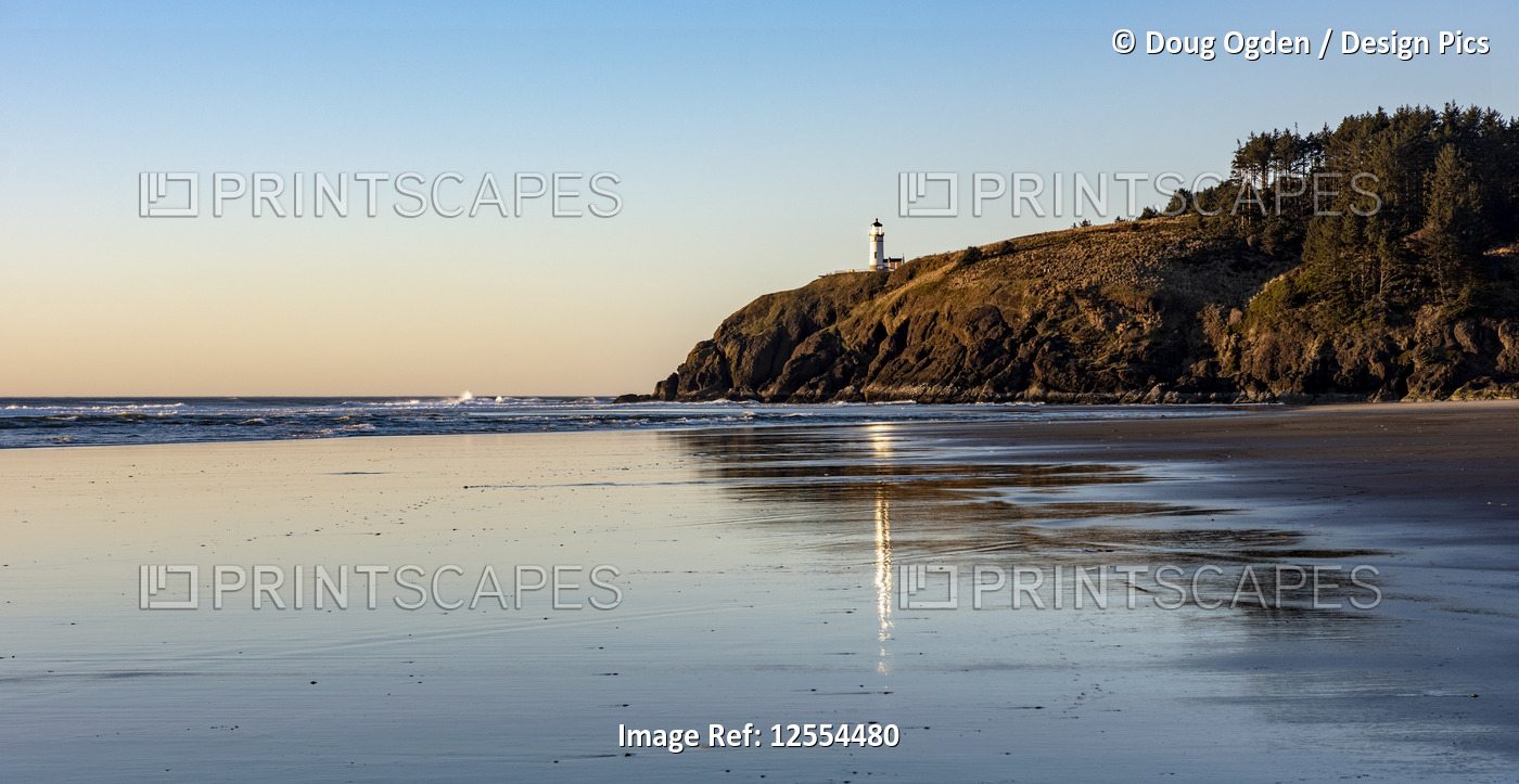 The Cape Disappointment North Head Lighthouse reflects on the wet sands at ...