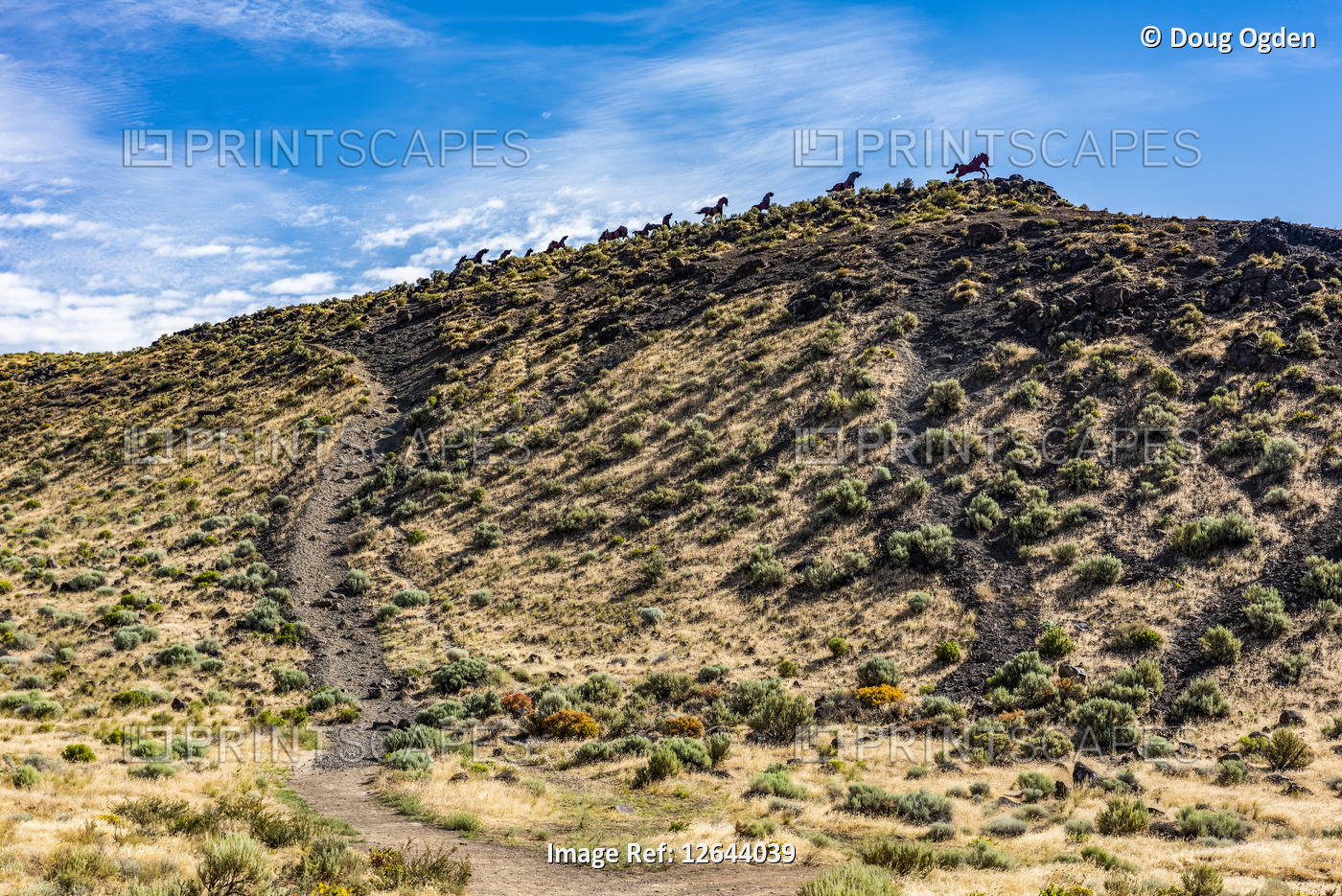 Metal art depicting wild horses running across a ridge atop the Wild Horse ...