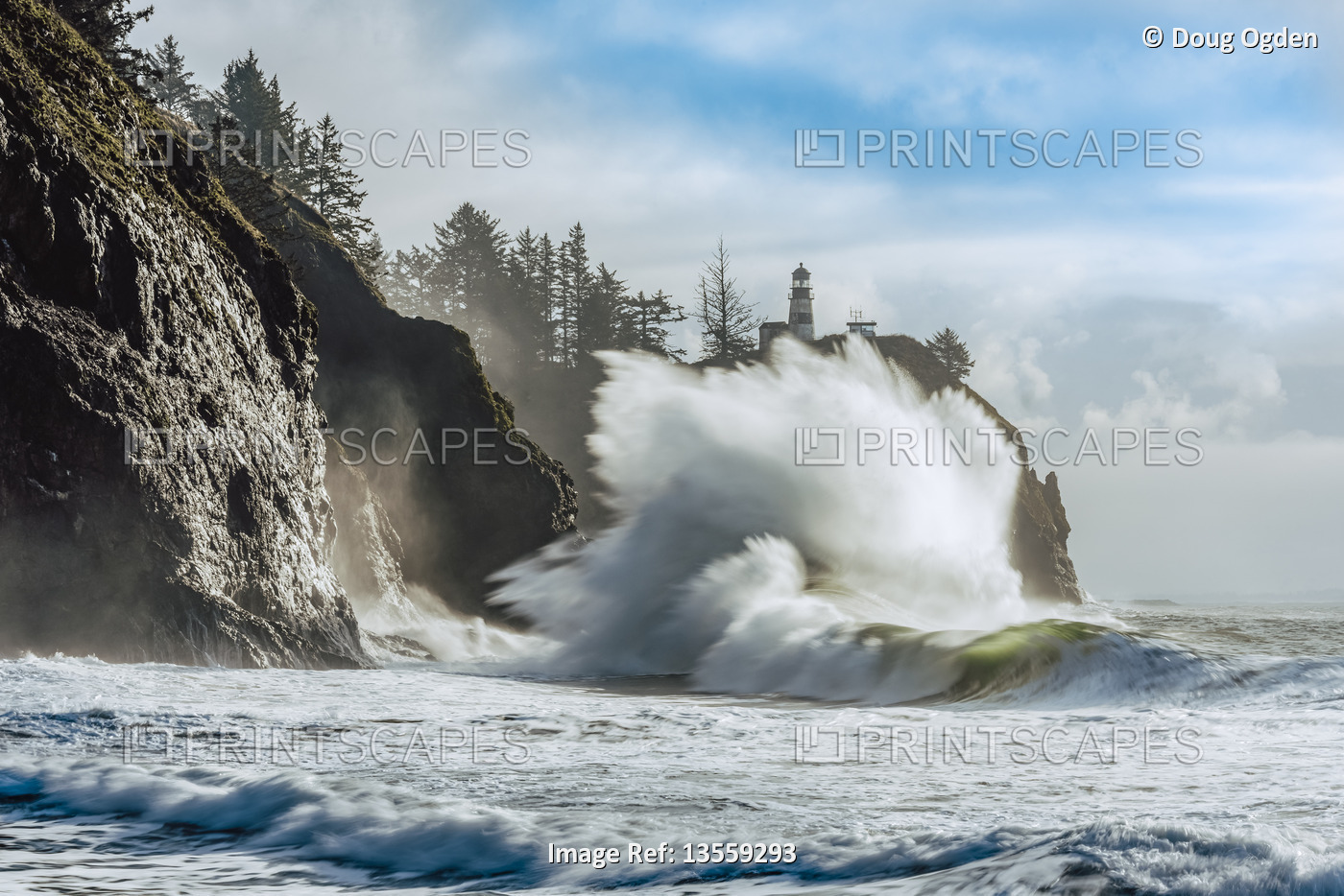 Cape Disappointment Light with large waves crashing in onto the beach below, ...