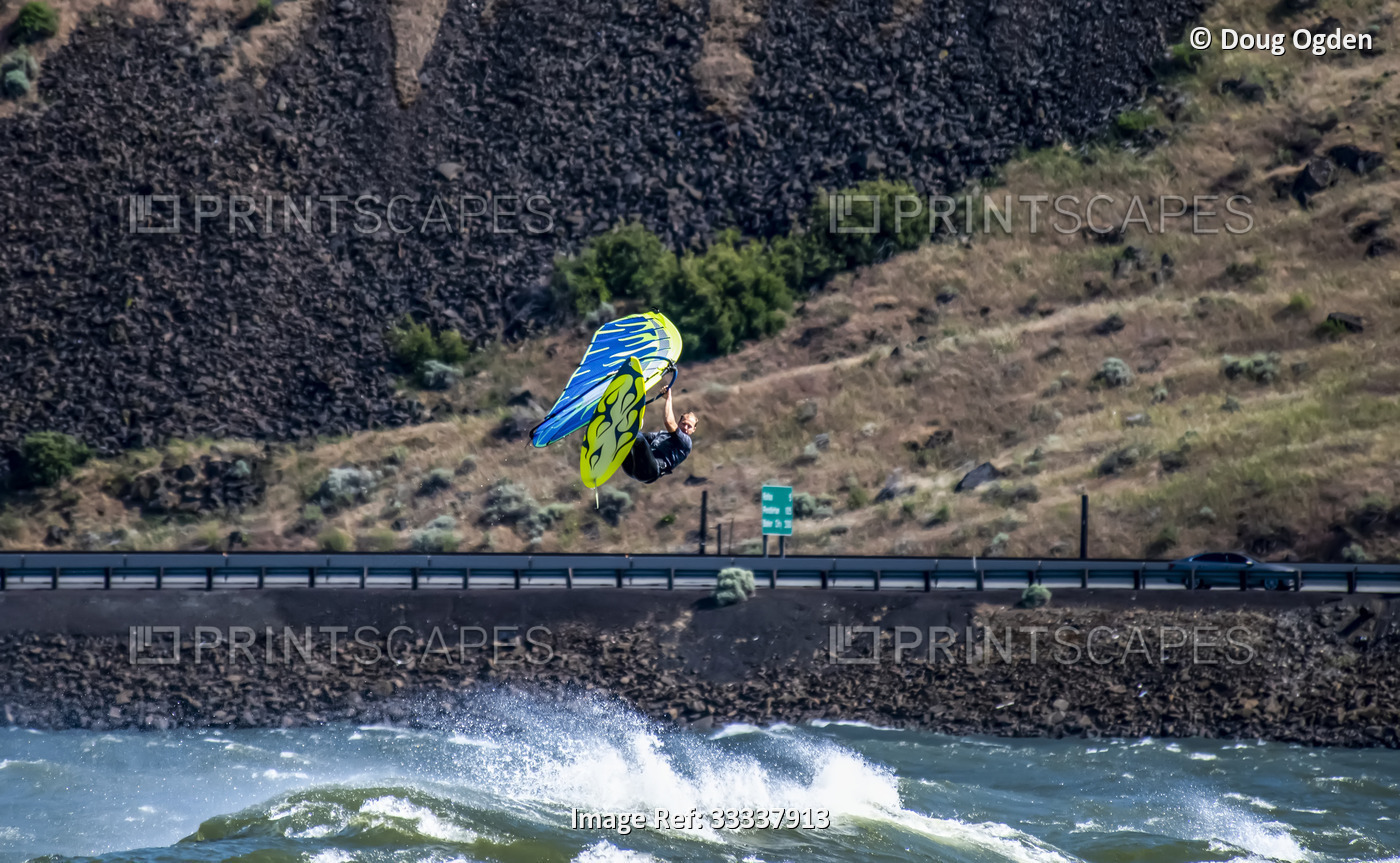 An expert Windsurfer getting big air while riding the waves and the wind on the ...