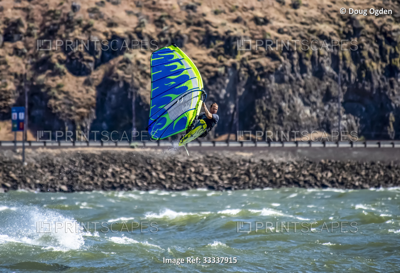 An expert Windsurfer getting big air while riding the waves and the wind on the ...