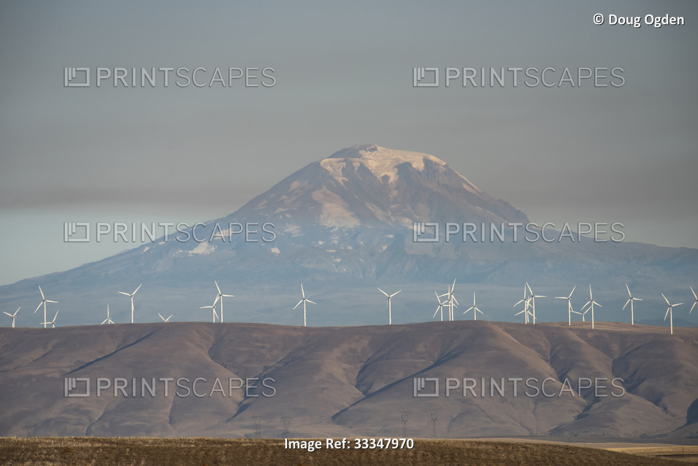 Foothills lined with wind turbines under a smoky sky from a wild fire with ...