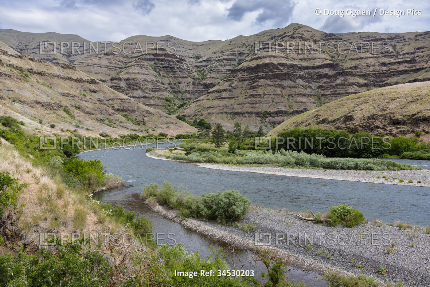 Gravel bars of the wild Snake River and the exposed geologic and eroding cliffs ...
