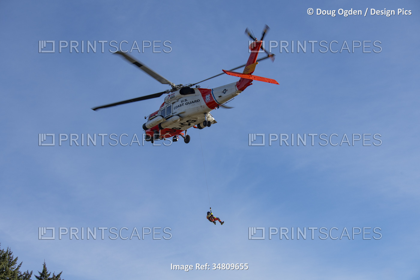 U. S. Coast Guard crewman suspended below a Sikorsky MH-60J Jayhawk Performing ...